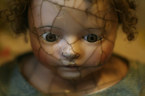 Photo of antique procelain doll wil cracks on face